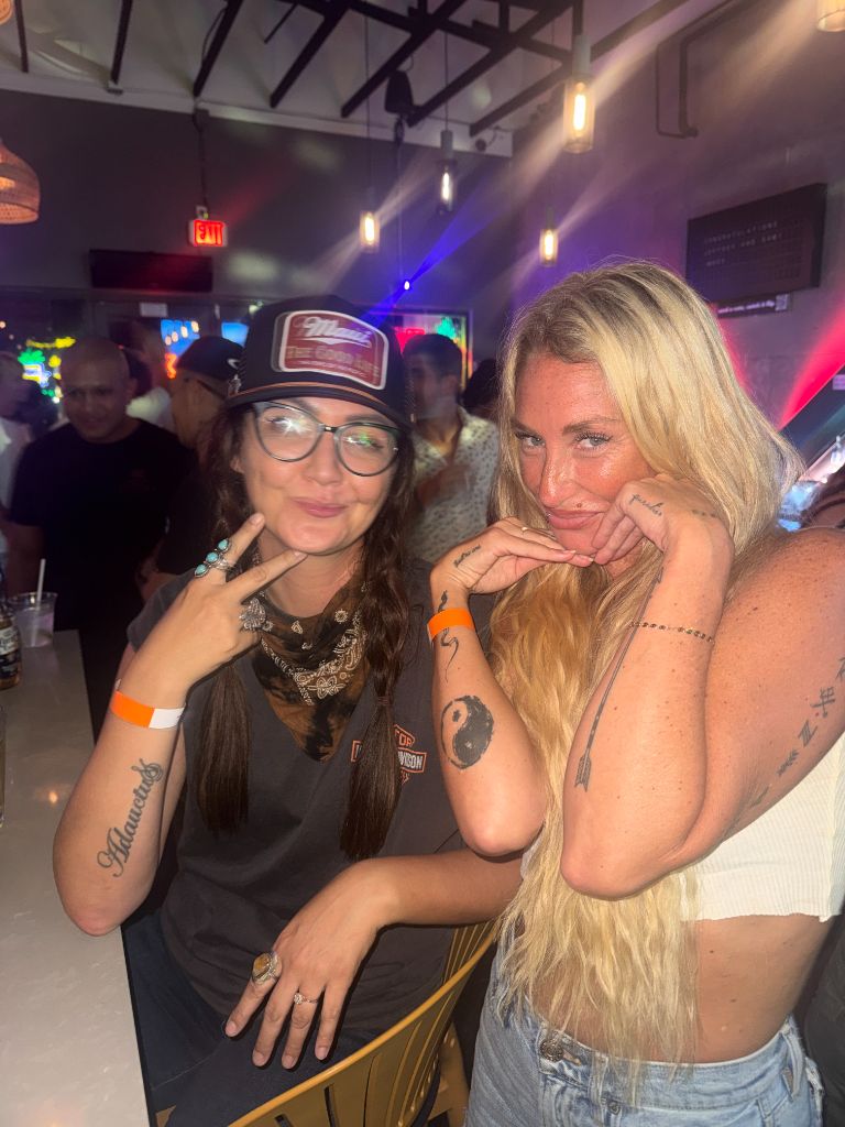 Kris Bradley with a friend at a Maui bar in the evening.