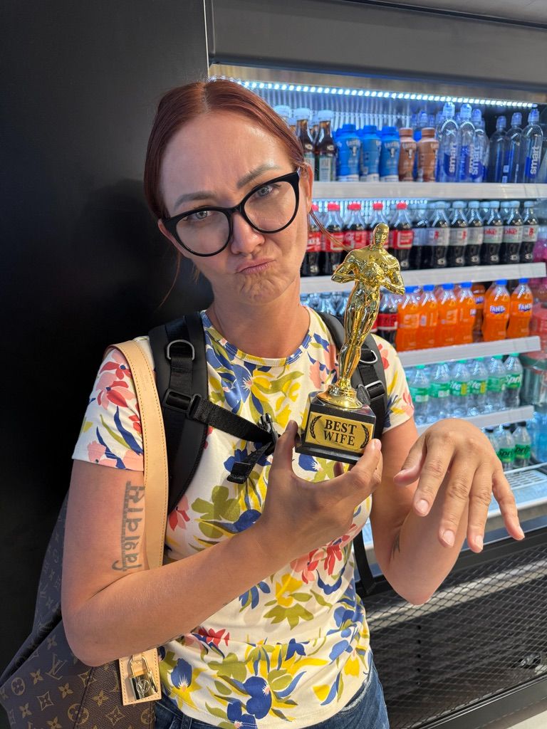Kris Bradley holding a playful "Best Wife" trophy.