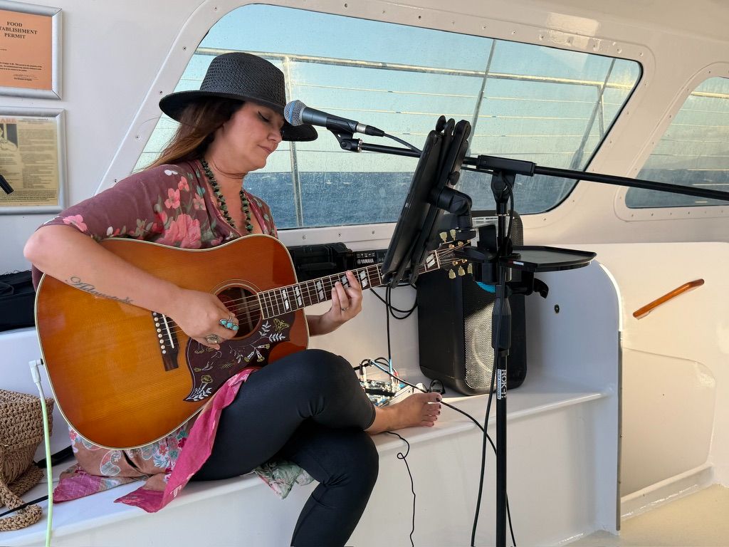 Kris Bradley singing during a boat performance.