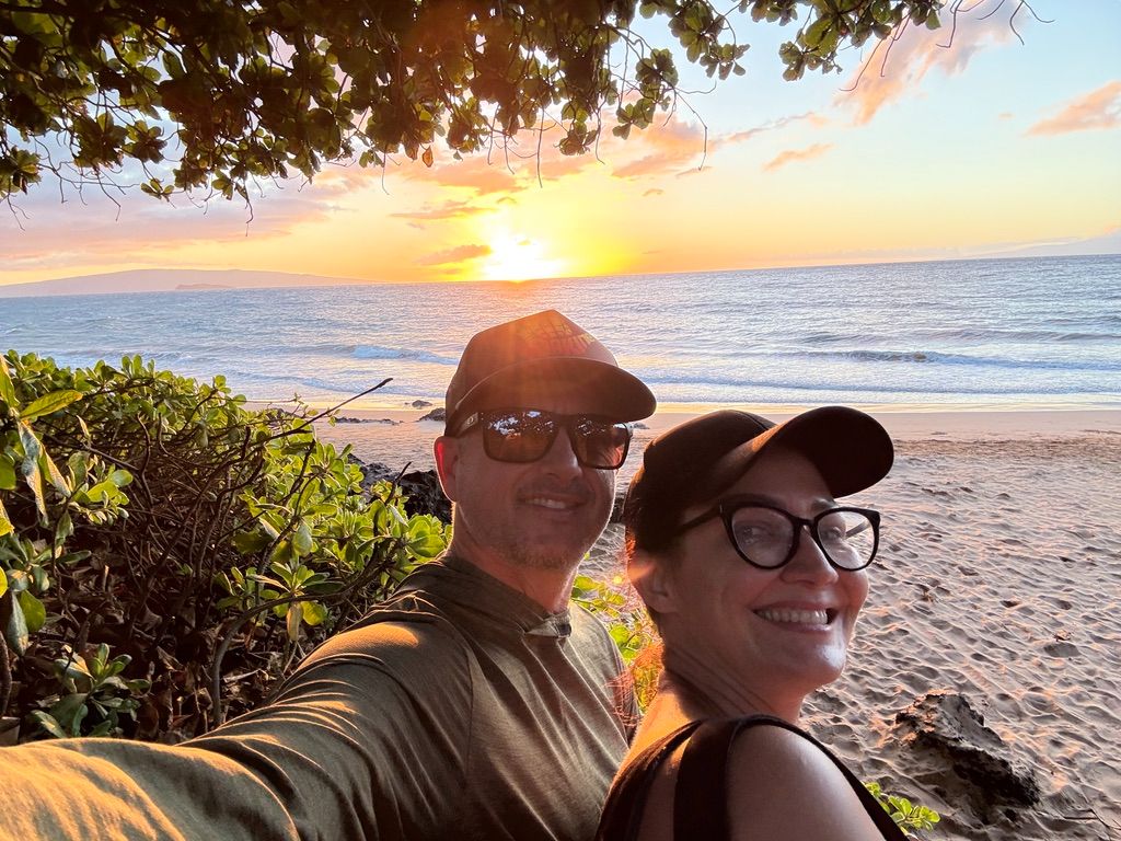 Kris Bradley and her husband at a Maui beach at sunset.